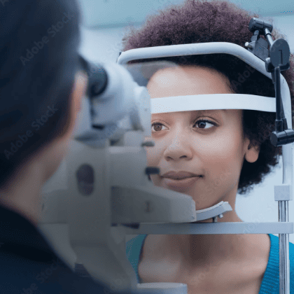 Um médico examinando o olho de uma paciente com um topógrafo de córnea